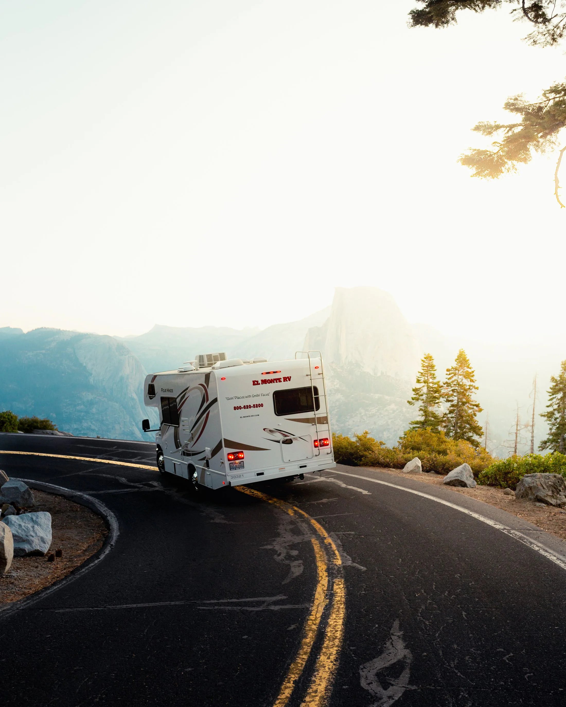 An RV moving through a wide mountain landscape