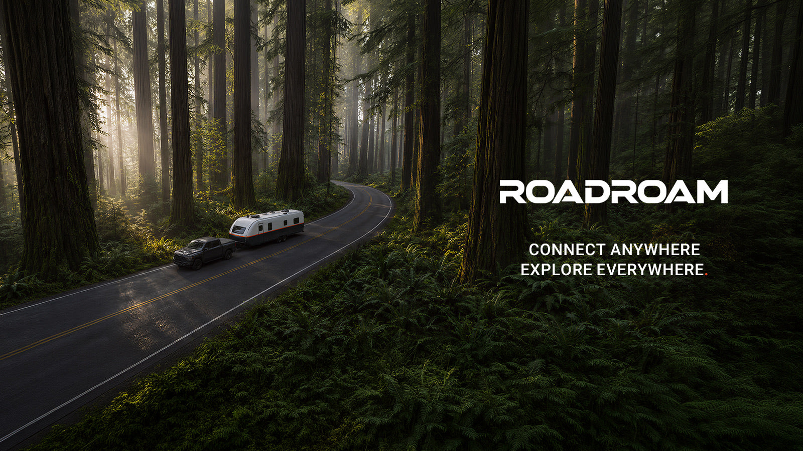 ROADROAM travel trailer driving through a forest